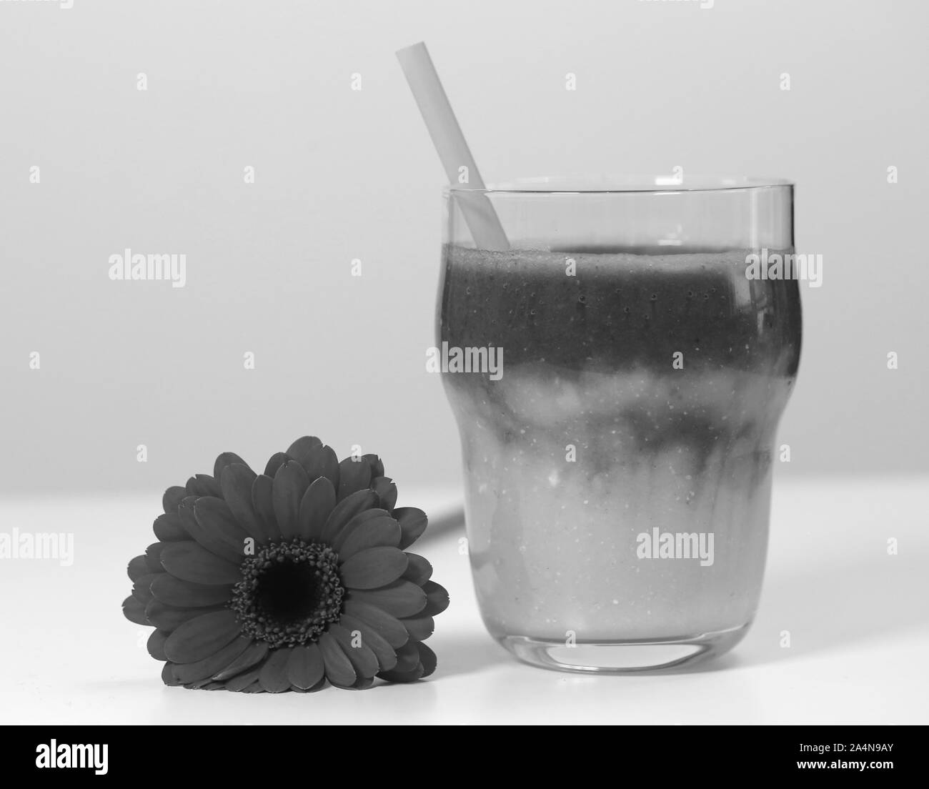 Healthy and delicious homemade smoothie(s) with a flower on a table. Closeup still life image. Healthy, delicious and nutritious snack, yummy! Stock Photo
