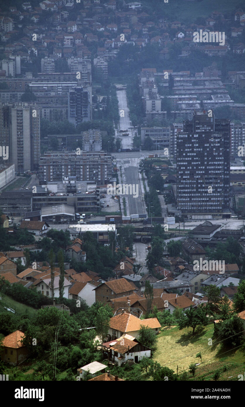 6th June 1993 During the Siege of Sarajevo: the view south from Hum Hill along Hamdije Čemerlića Street, known as Bratstva i Jedinstva (the street of 'Brotherhood and Unity') during the war. The street crosses Sniper Alley and the Miljacka River, into Bosnian-Serb-held Grbavica. At various points lorries and containers act as sniper barriers. Stock Photo