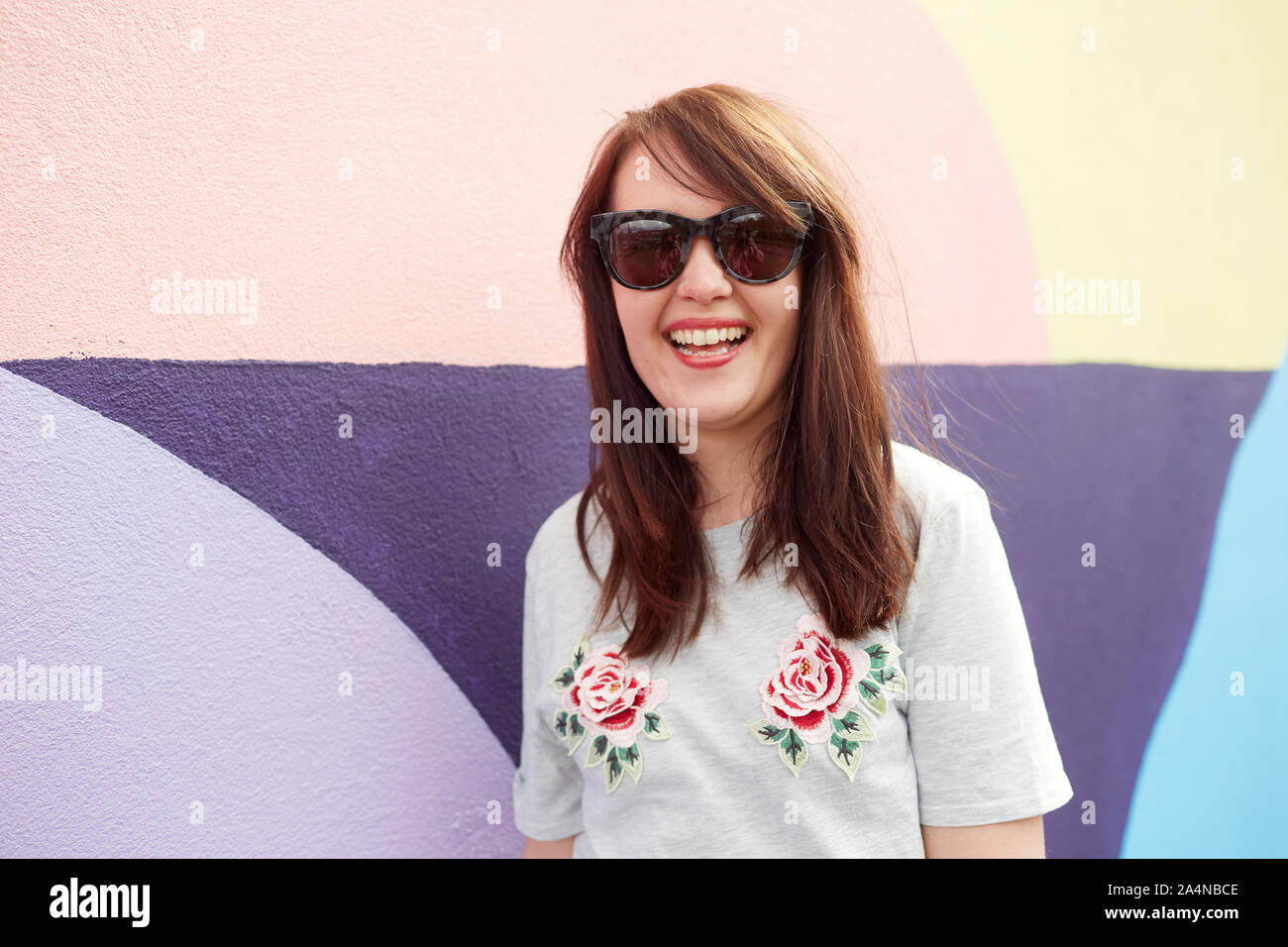 Young woman standing in front of painted wall Stock Photo