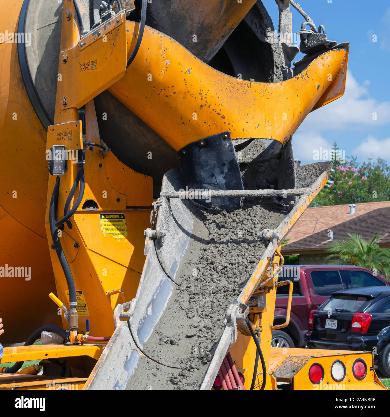 Wet concrete in the chute of a concrete mixing truck. Stock Photo