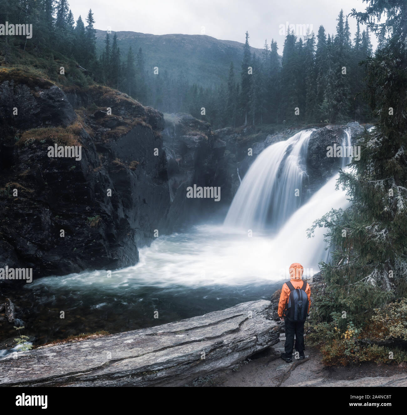 Hiker looking at waterfall Stock Photo