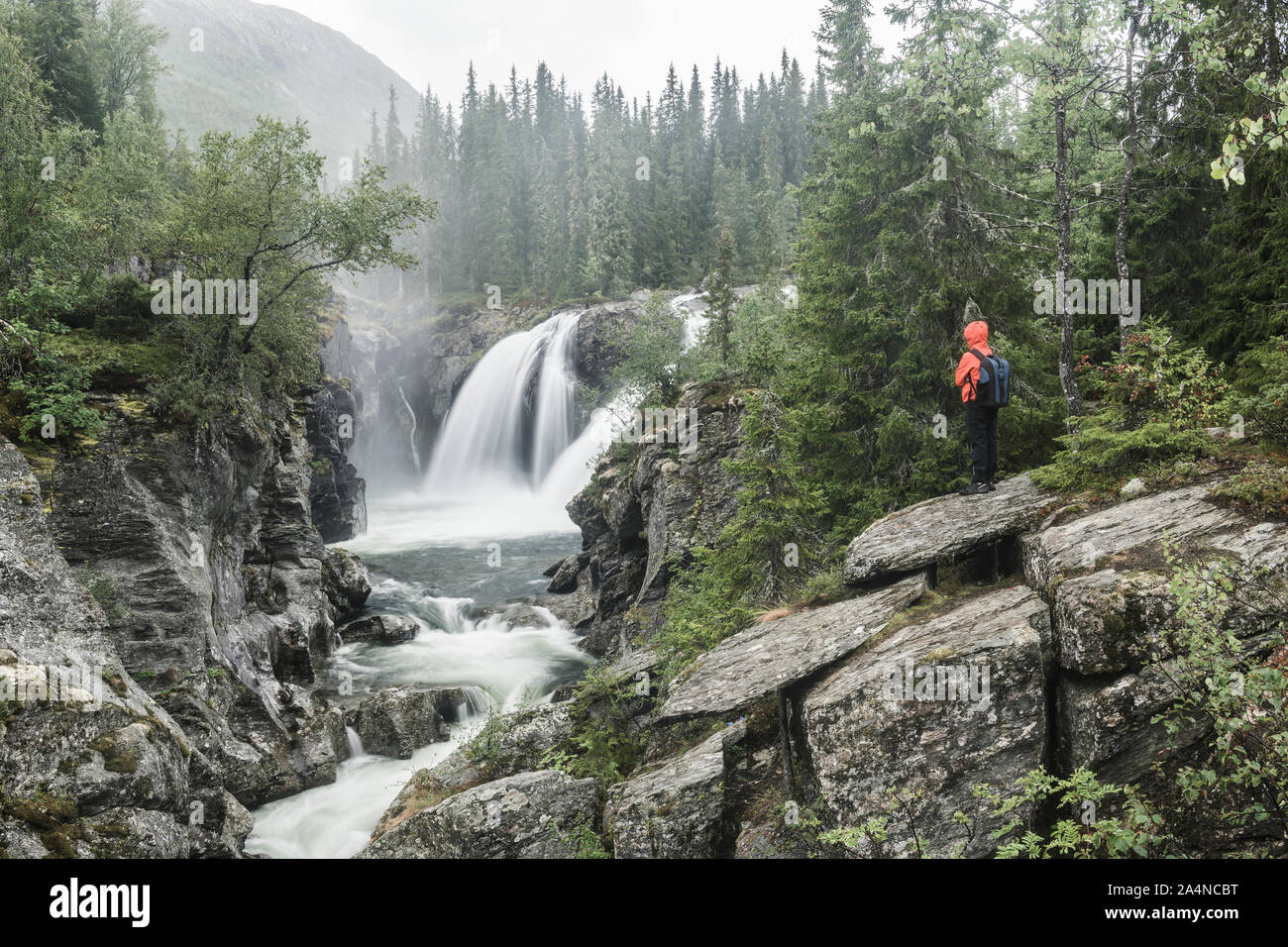 Hiker looking at waterfall Stock Photo