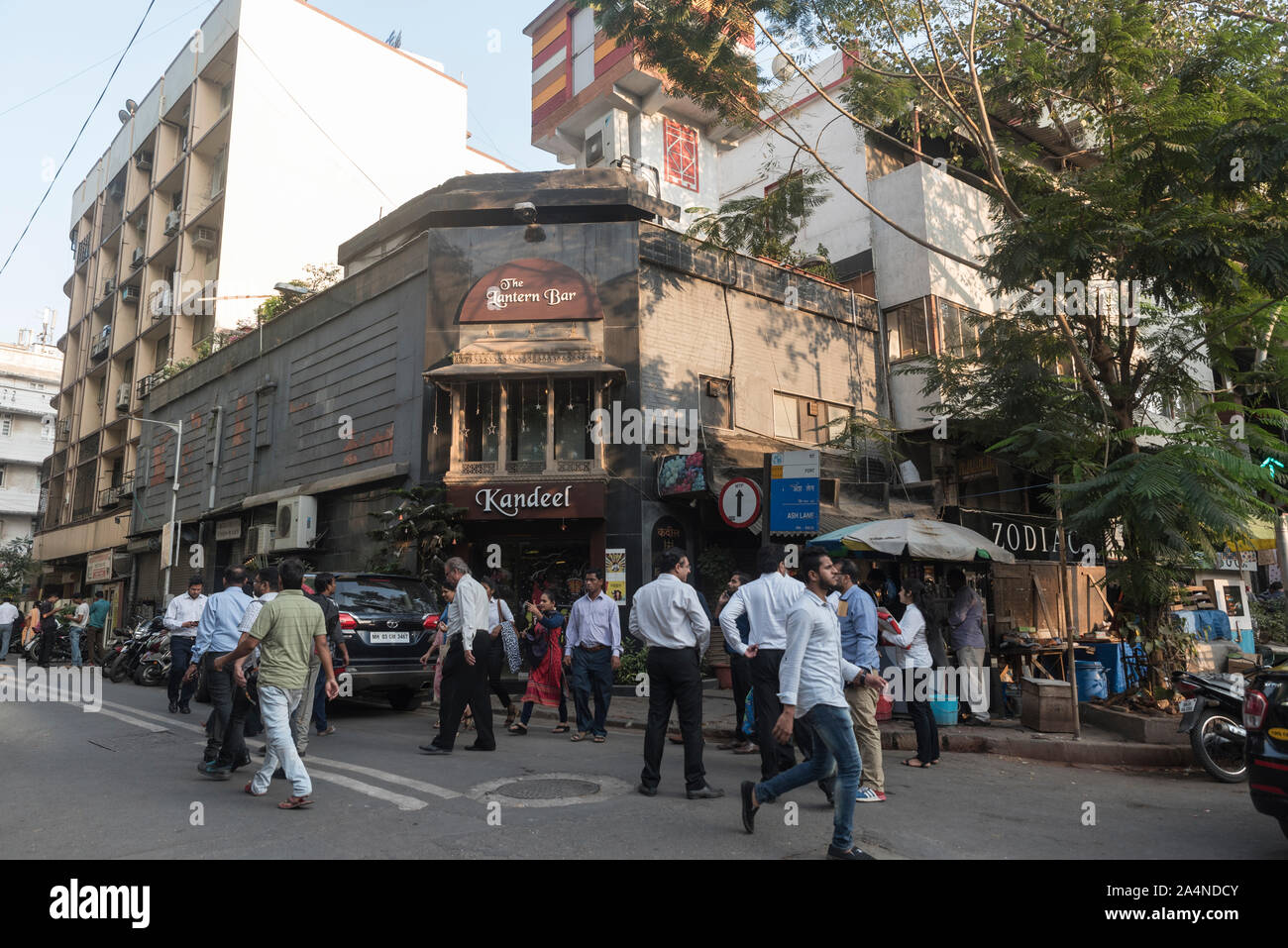 Office goers walk in front of Kandeel restaurant in the fort area of Mumbai, India. This is also known as the art district of Mumbai. Stock Photo