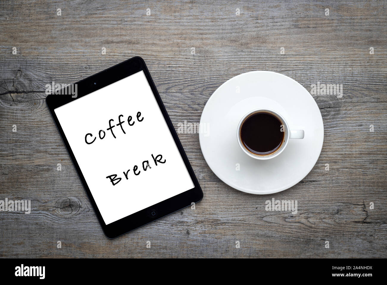 cup of coffee with beans on a wooden table with a tablet with 'coffee break' message Stock Photo