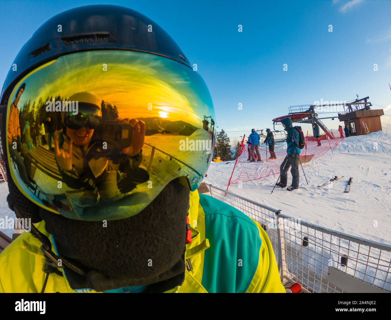 man in ski mask close up. reflection. snowed mountains on sunset Stock Photo