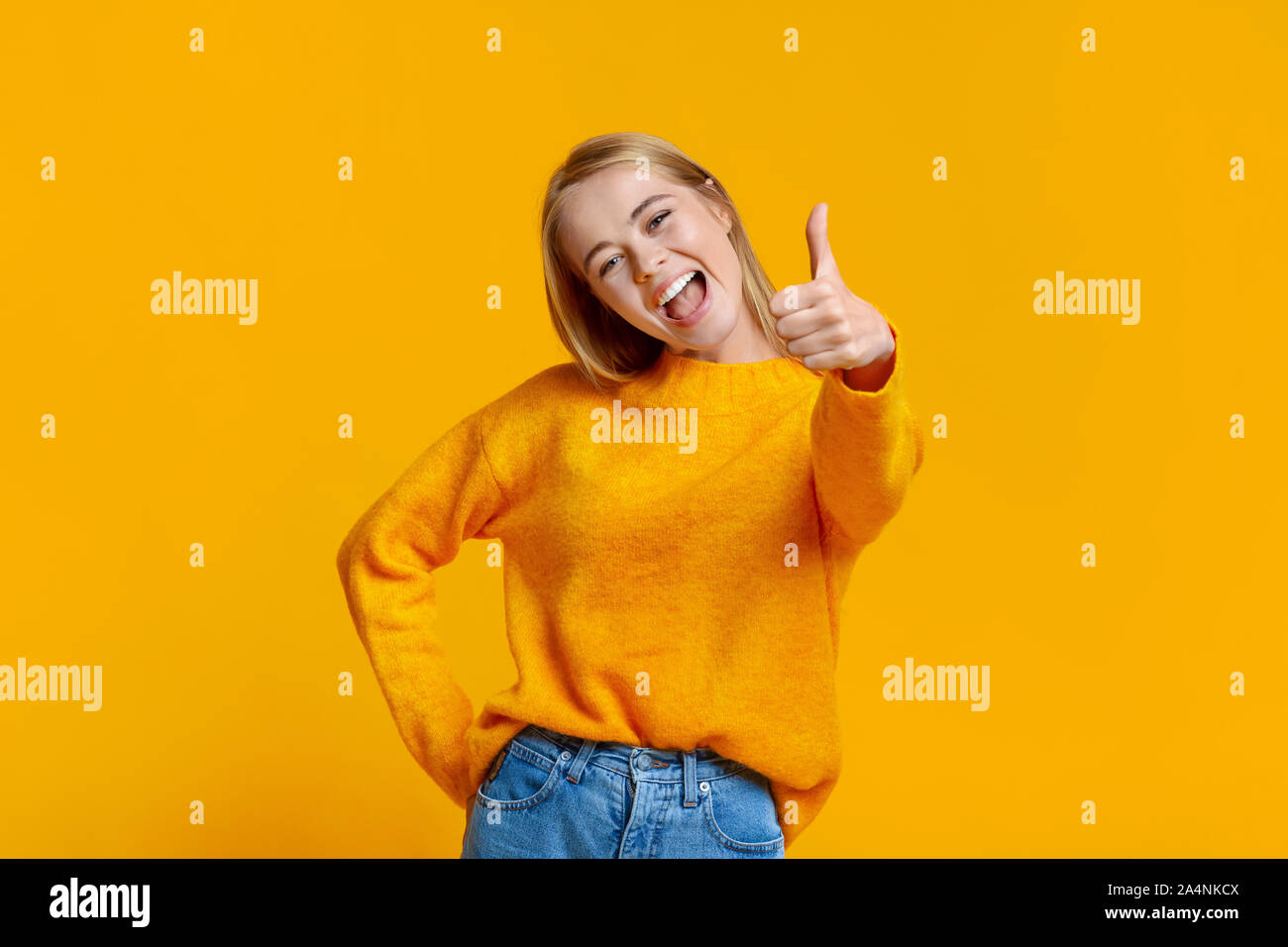 Carefree teen girl showing thumb up, recommending something Stock Photo