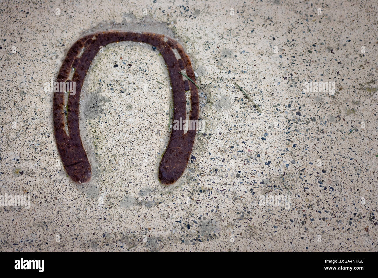 Rusted horseshoe lying on asphalt. Stock Photo