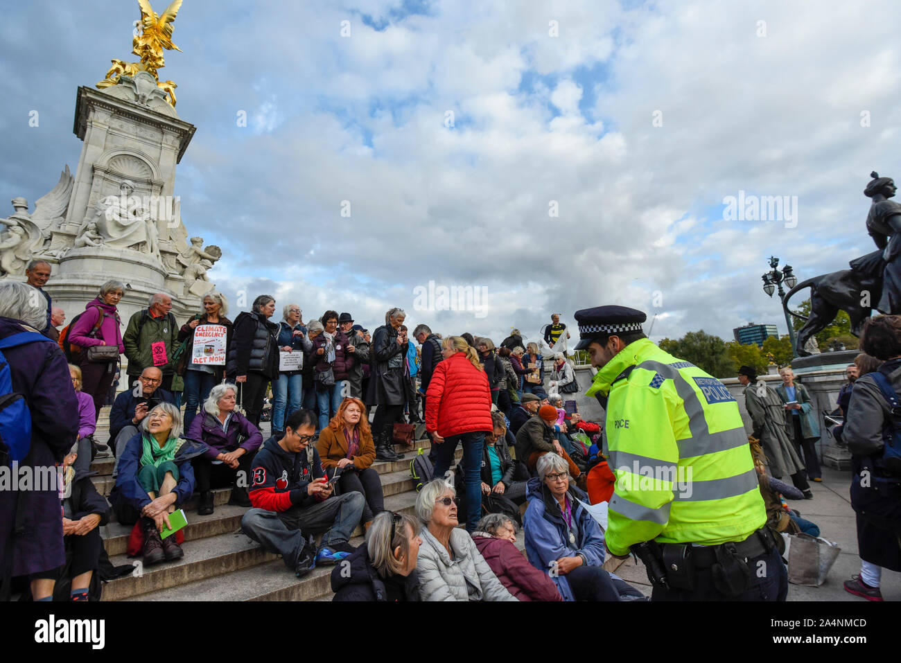 London, UK.  15 October 2019. A police officer reads a Section 14 notice to climate activists from Extinction Rebellion staging a Grandparents protest on the Queen Victoria Memorial outside Buckingham Palace.  Activists are calling on the government to take immediate action against the negative effects of climate change. Credit: Stephen Chung / Alamy Live News Stock Photo