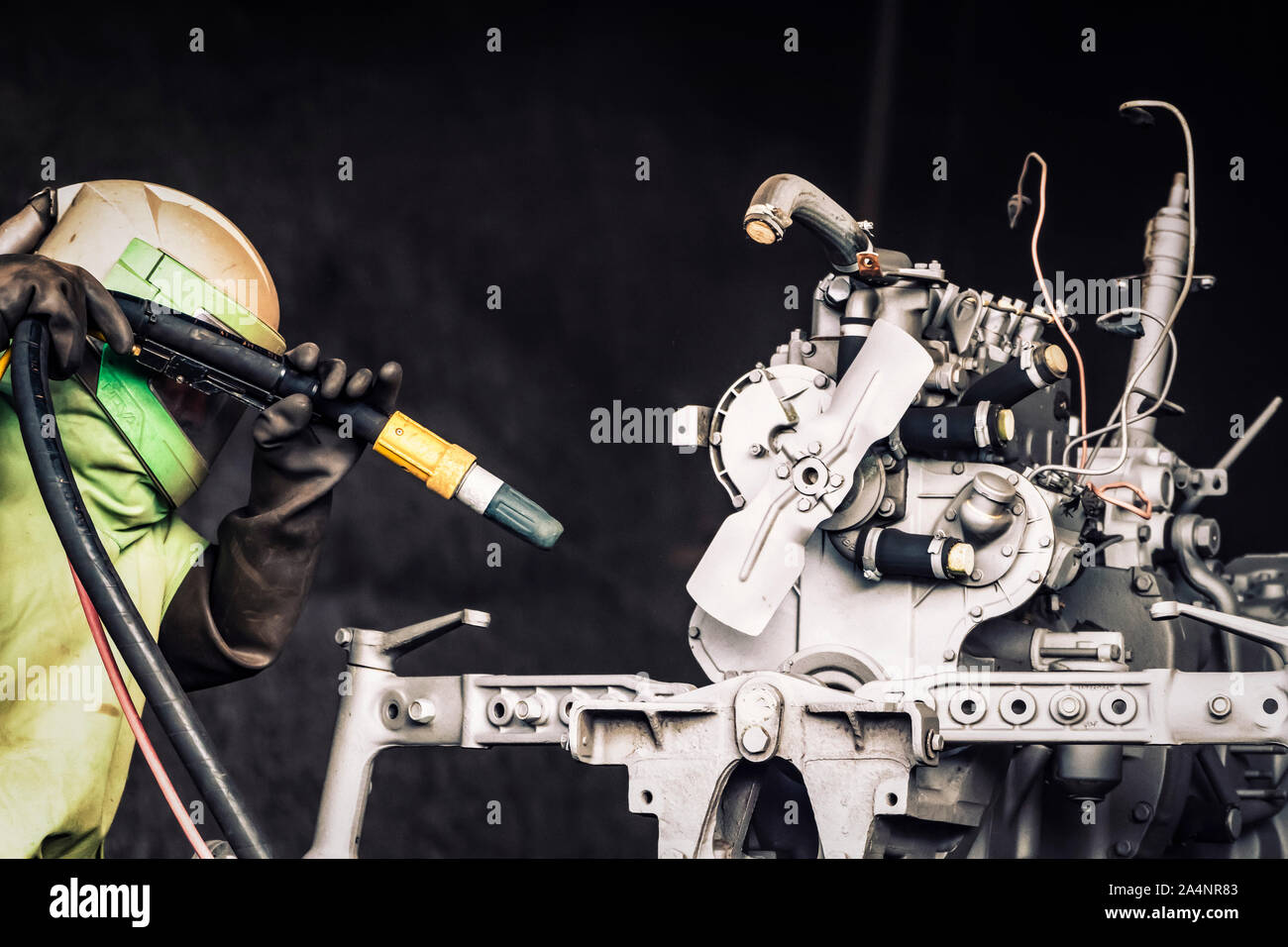 Sandblasting. Enthusiastic restorer blasting chassis and engine body of