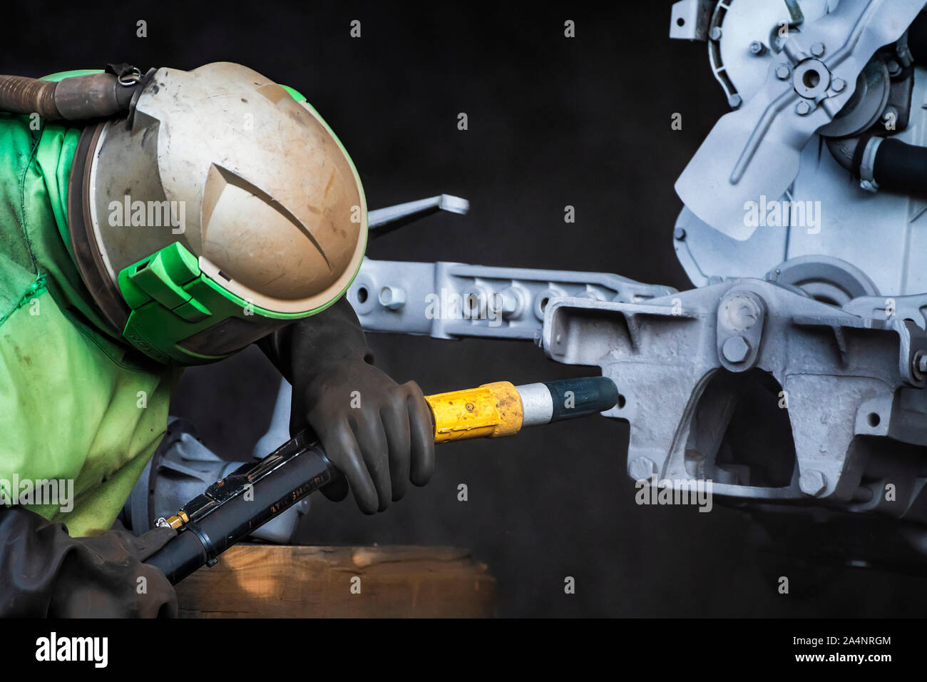 Sandblasting. Enthusiastic restorer blasting chassis and engine body of