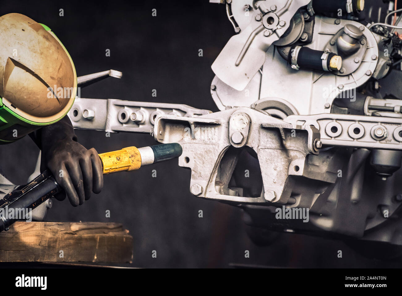 Sandblasting. Enthusiastic restorer blasting chassis and engine body of