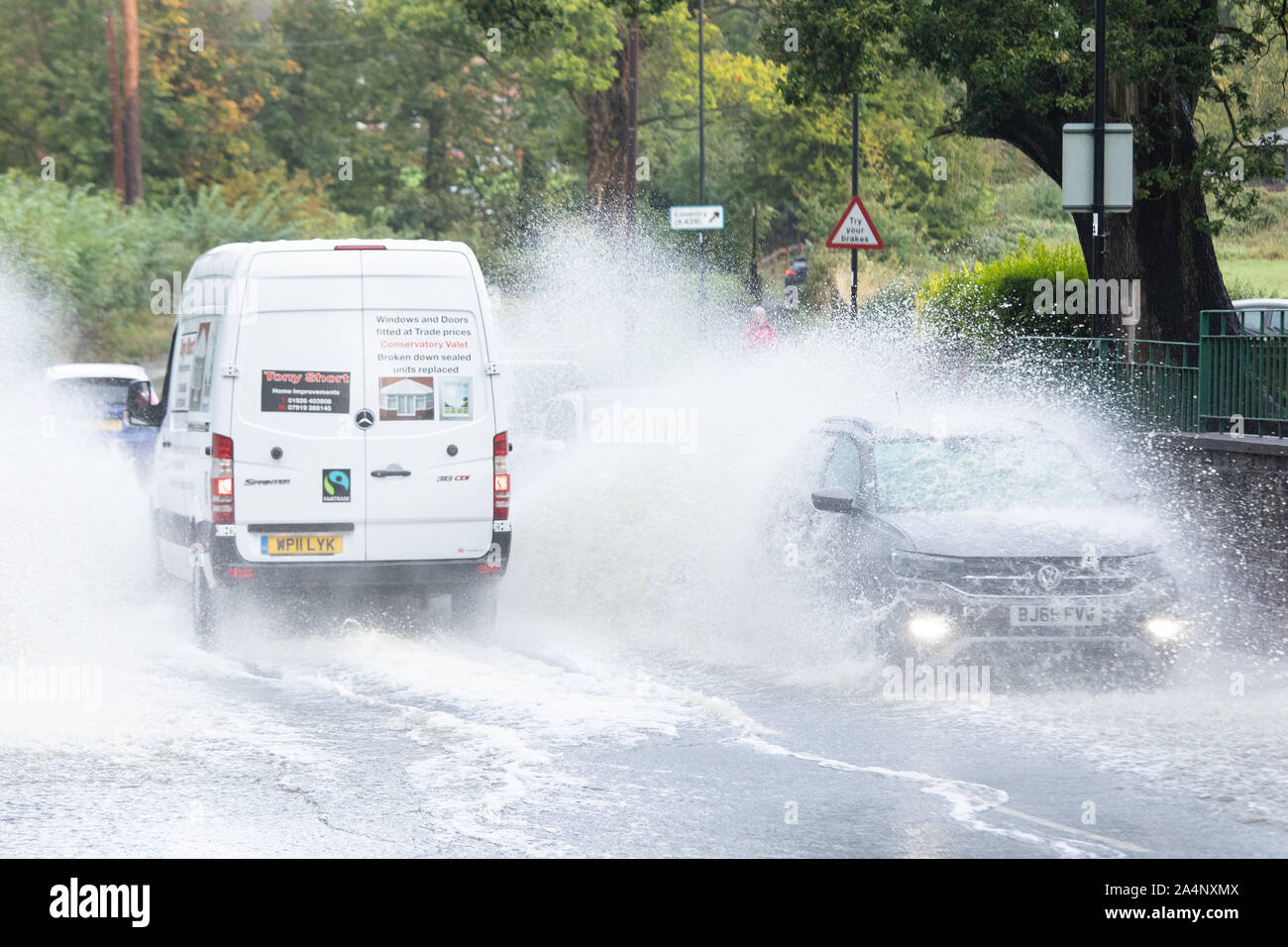 Cars driving through flood water hi-res stock photography and