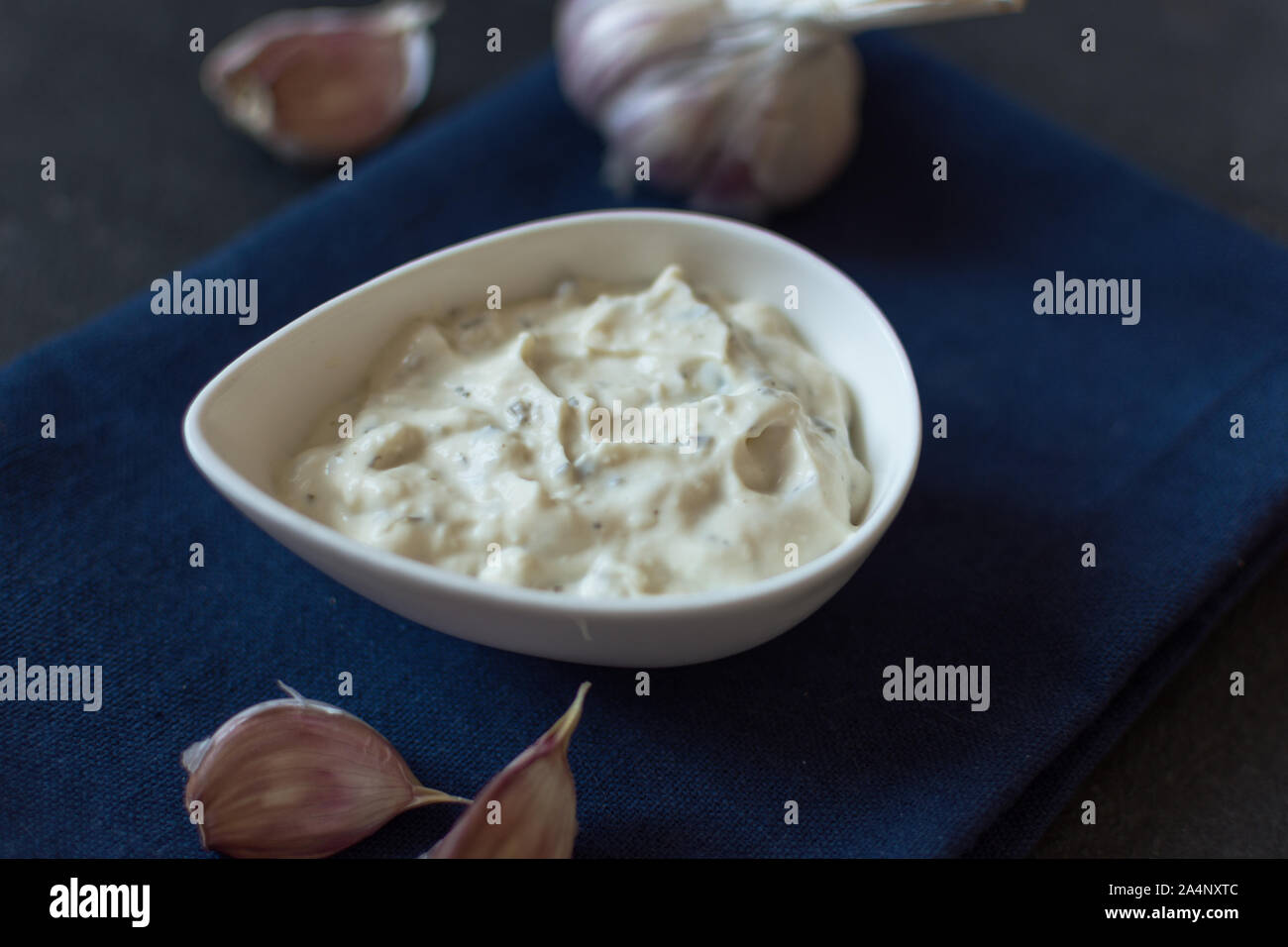 Garlic mayonnaise sauce in a small white plate . Selective focus