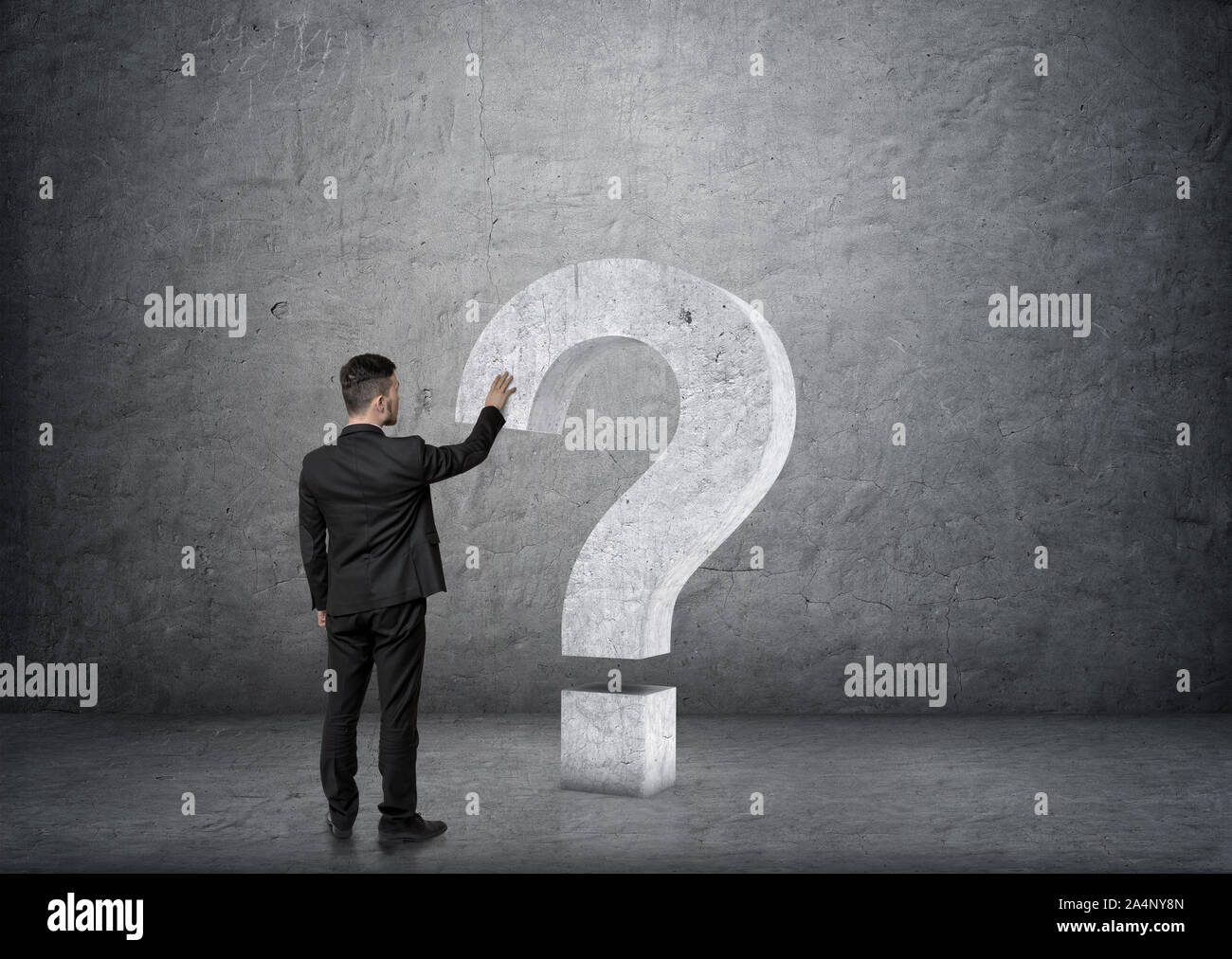 Back view of businessman touching big 3D concrete question mark Stock ...