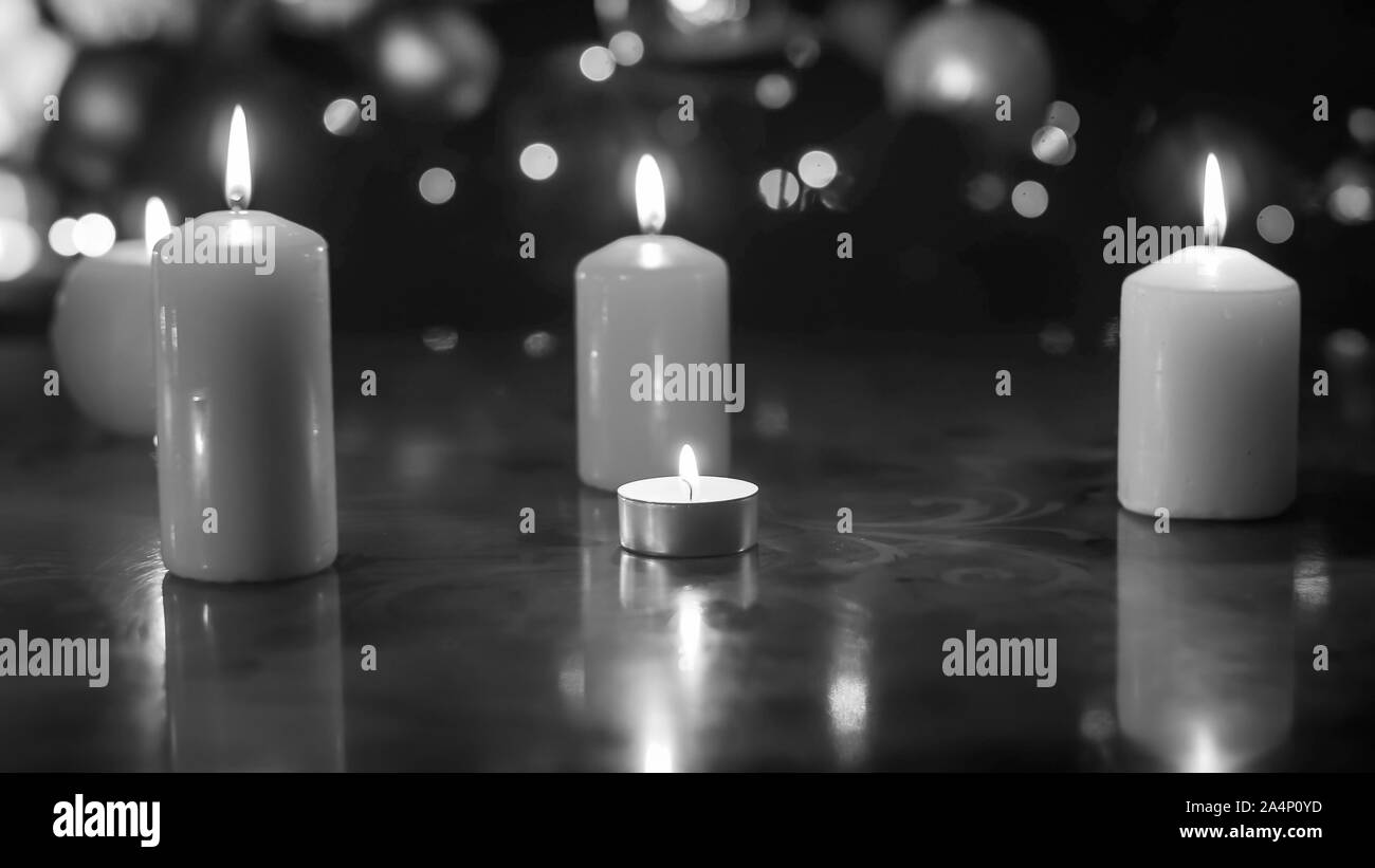 Closeup black and white image of burning candles on wooden table ...