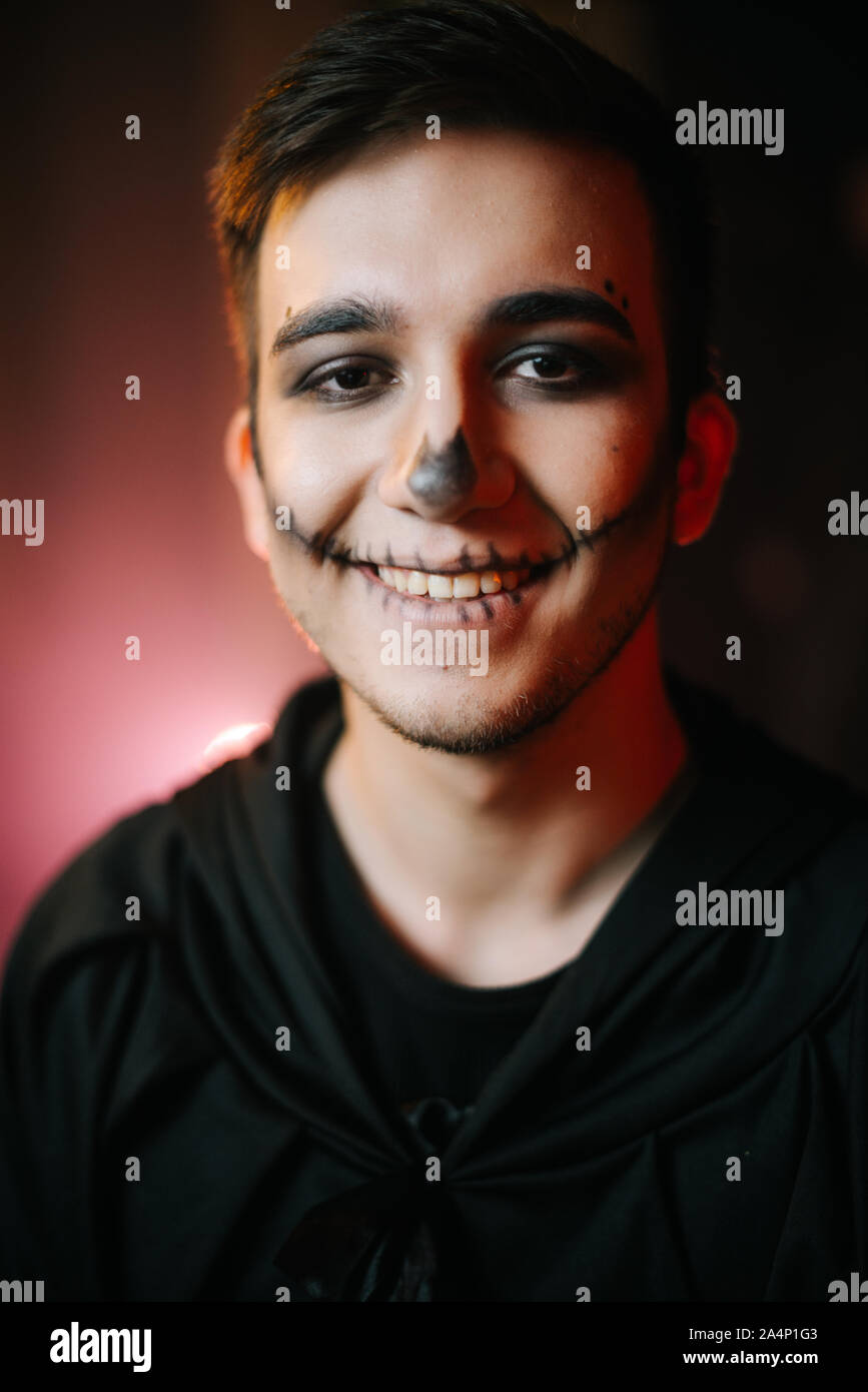 Young man with Halloween make-up smiling at the camera Stock Photo