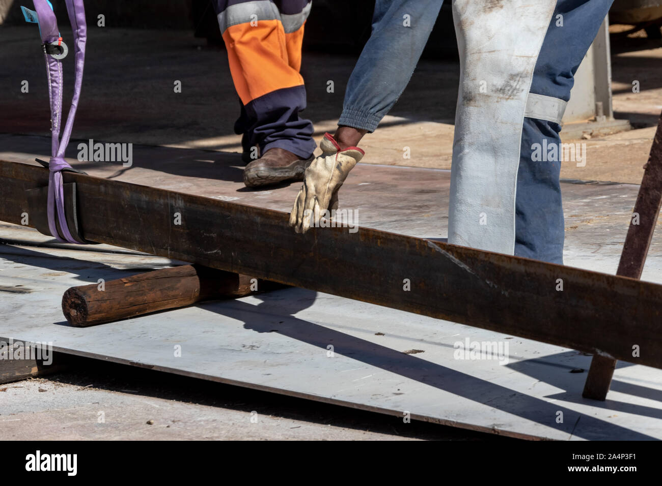 Worker crane lifting weights and a chain hoisting weight Stock Photo