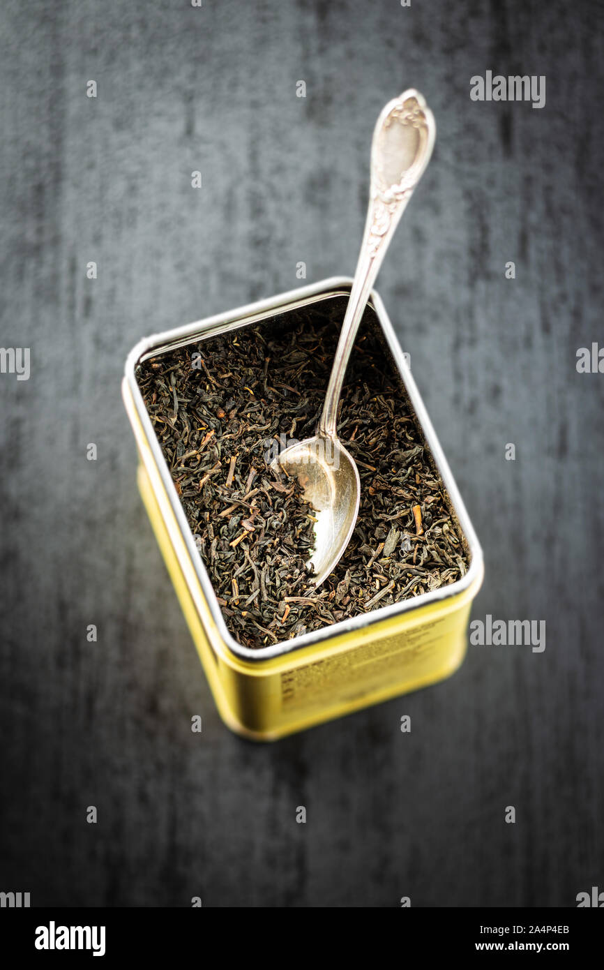 Dried black tea leaves in metal box. Stock Photo