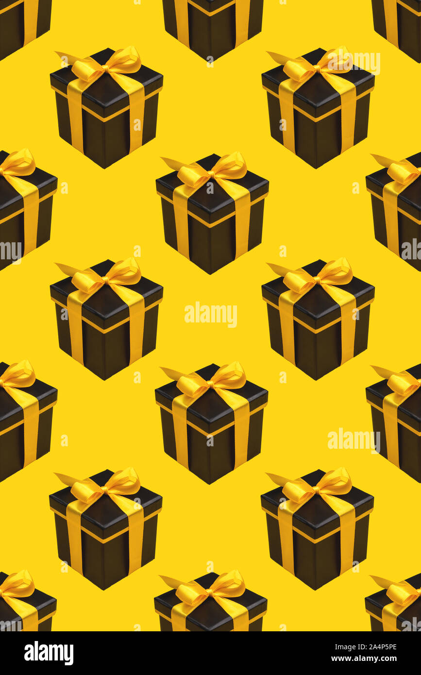 Pattern with lot of black gift boxes on yellow background. Stock Photo