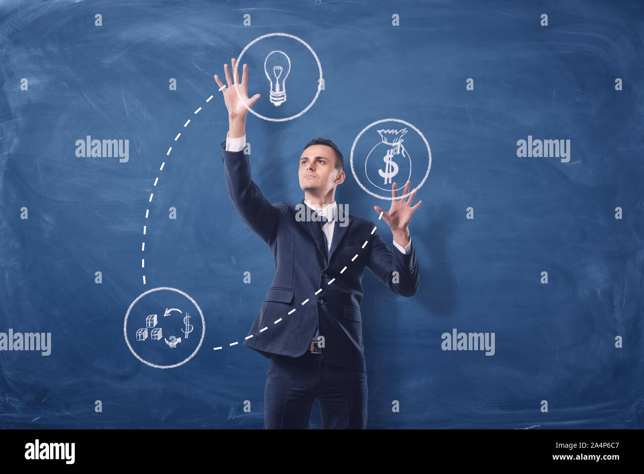 Businessman on blue chalkboard background manipulating white see-through icons that are connected with dash lines. Stock Photo