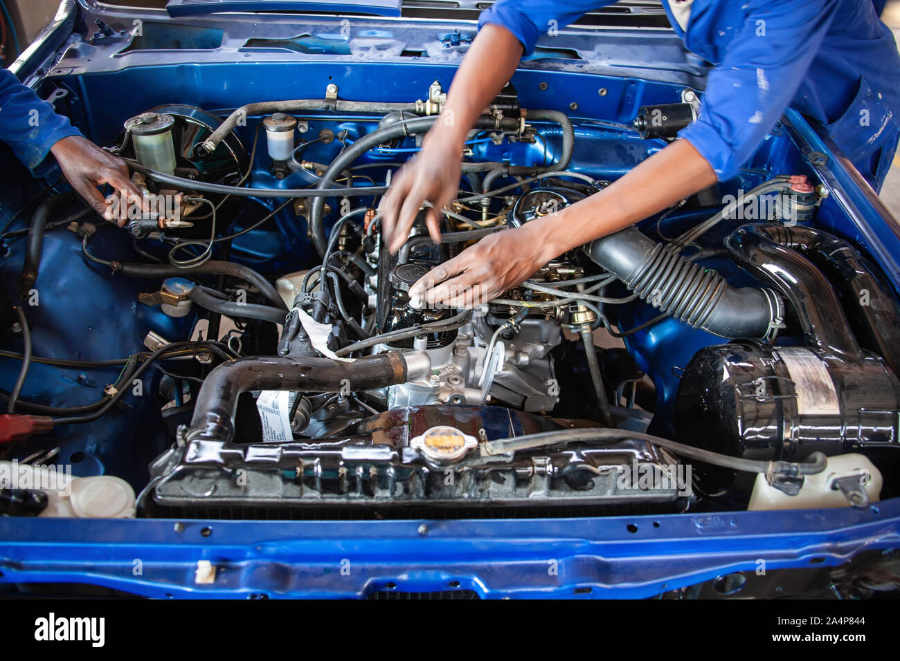 African Mechanics repairing a vintage car engine with carburetor Stock Photo