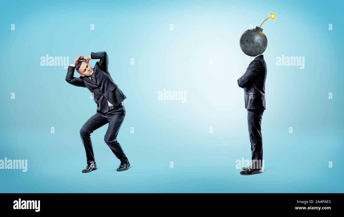 A businessman trying to hide and cover himself from another man with a bomb instead of his head