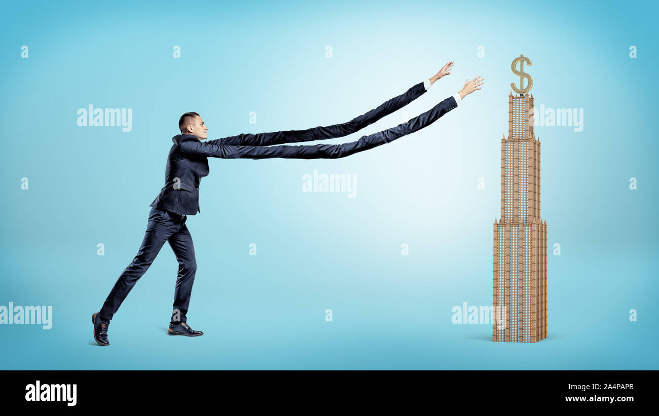 A businessman with extremely long arms trying to catch a small business building with a golden dollar sign on the top. Stock Photo