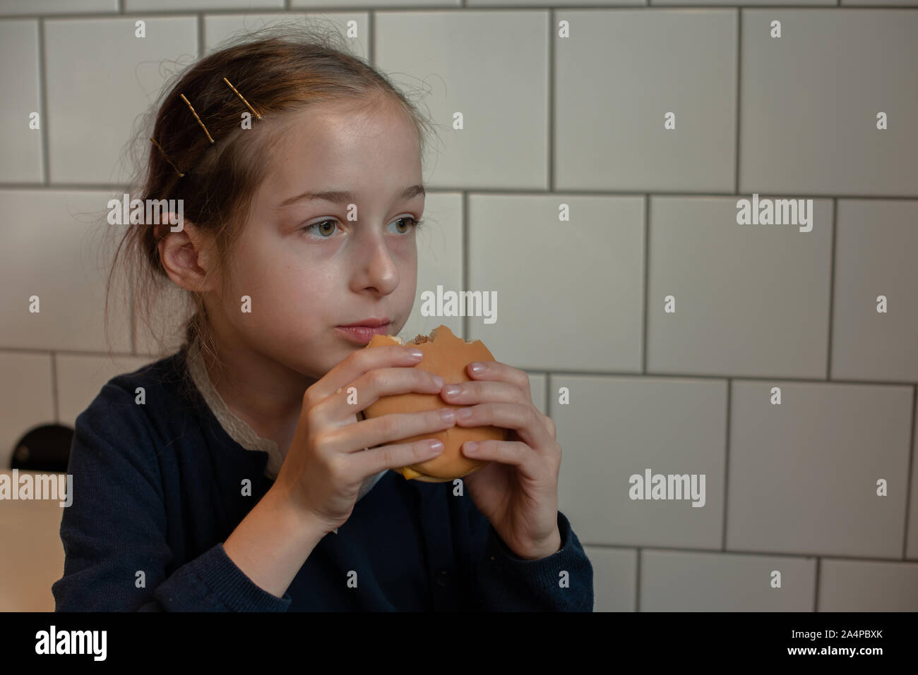 Happy teen girl eating a burger and french fries. Schoolgirl eating a ...