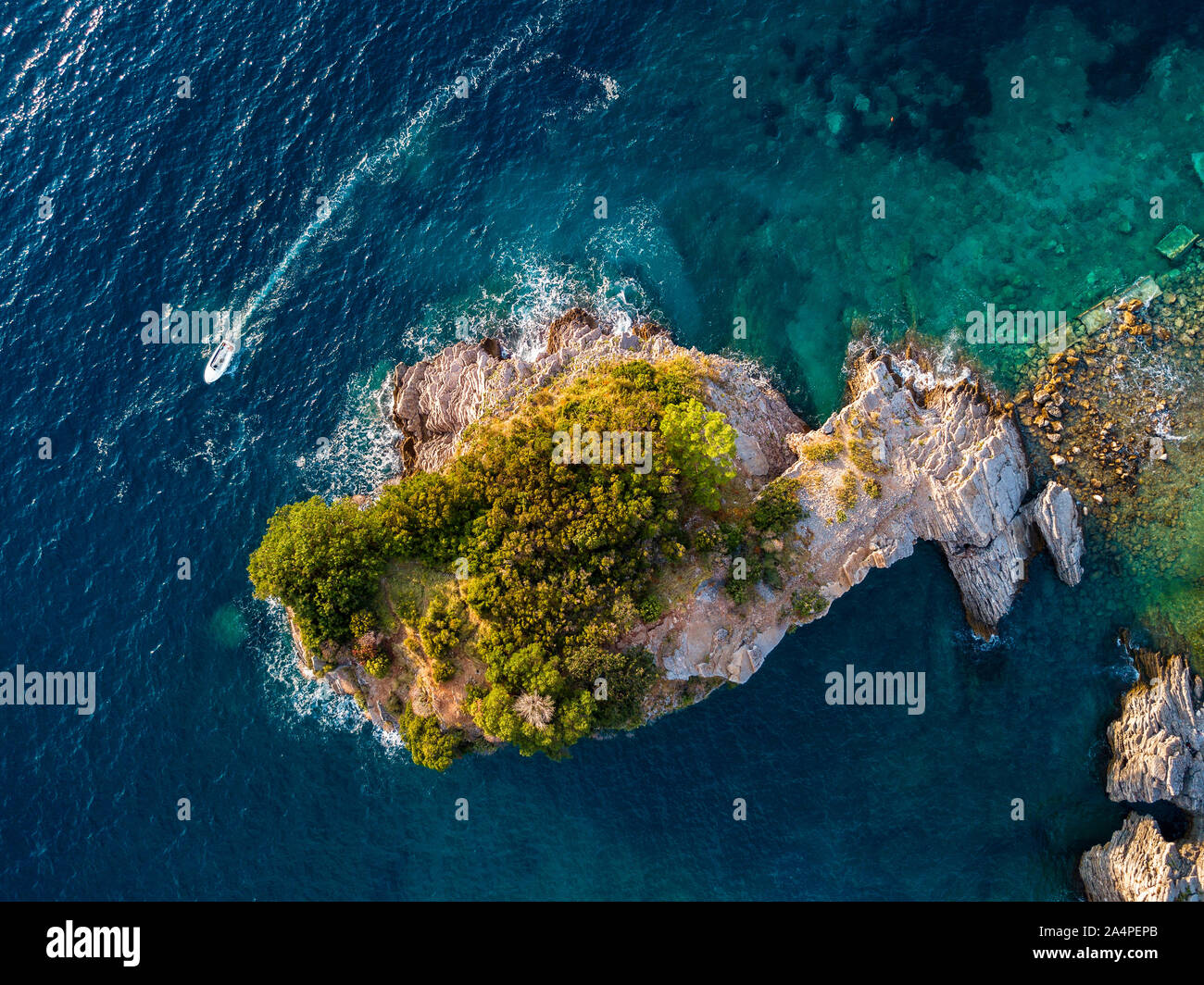 Aerial view of a speedboat hurtling near the island of Sveti Nikola, island of Budva, Montenegro. Jagged coasts with sheer cliffs and sea Stock Photo