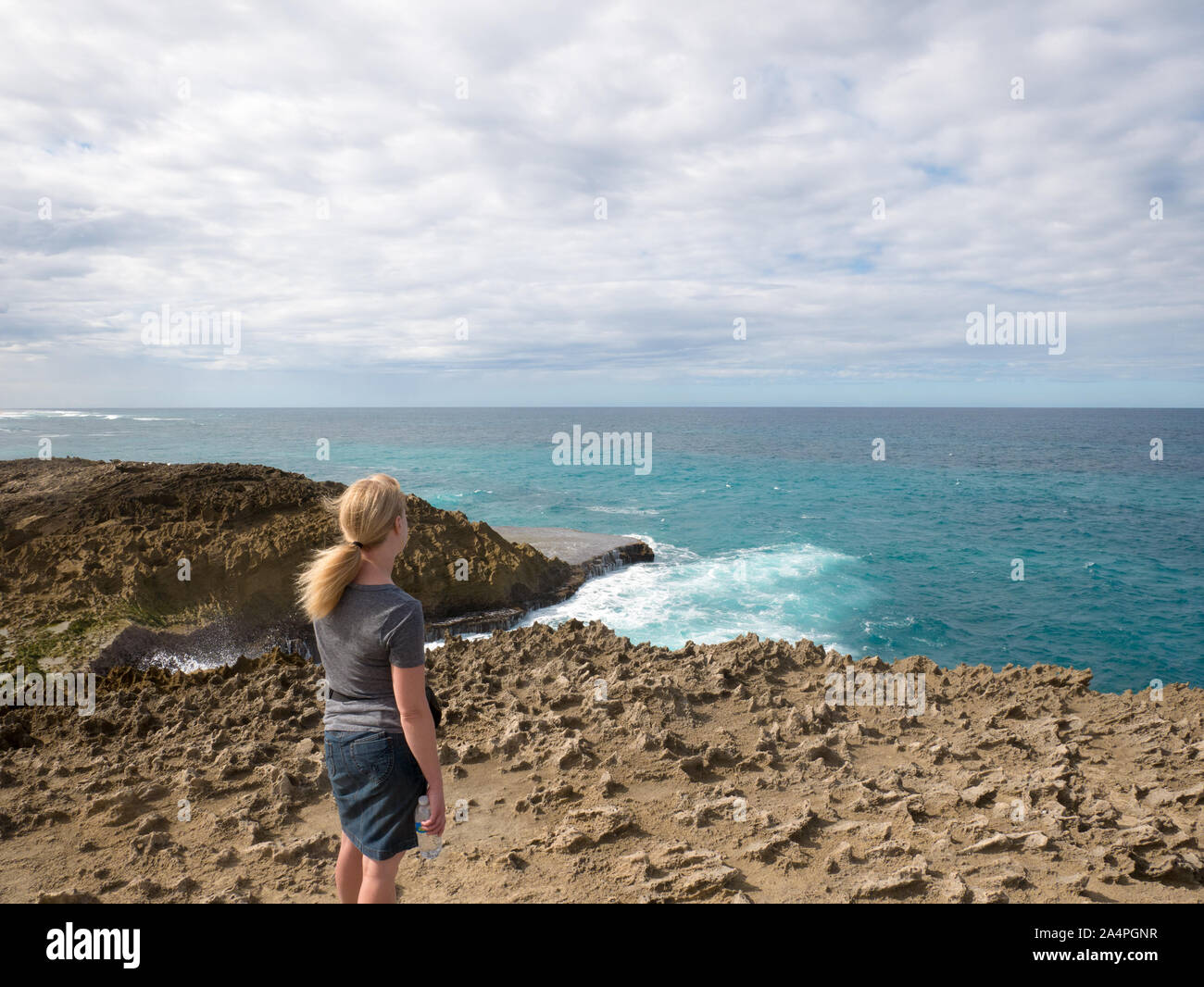 A woman is watching Huge waves collide against a reef near Jobos Beach in Puerto Rico, USA. Stock Photo