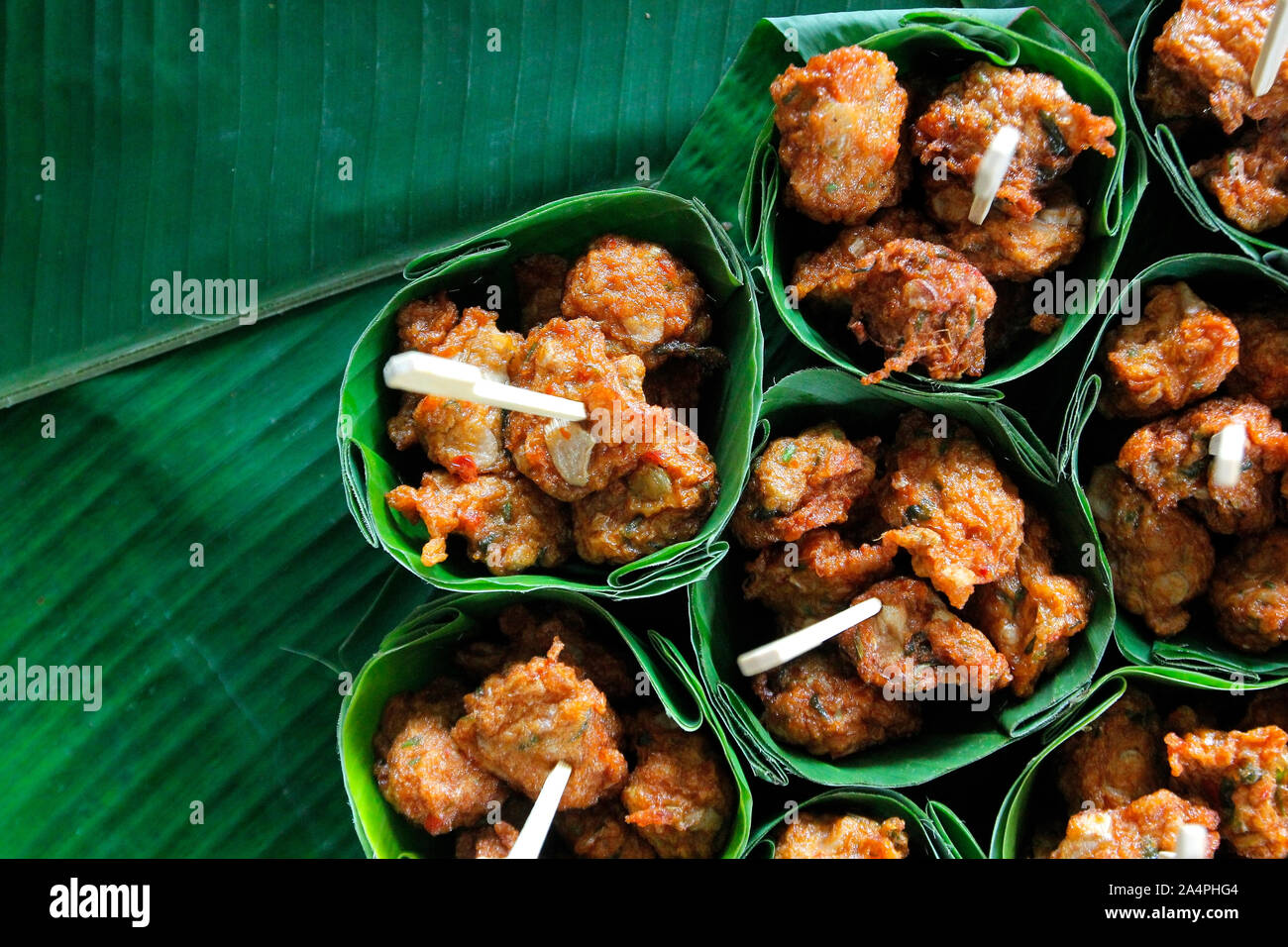thai food, fried fish-paste balls in banana leaves on buffet line Stock Photo