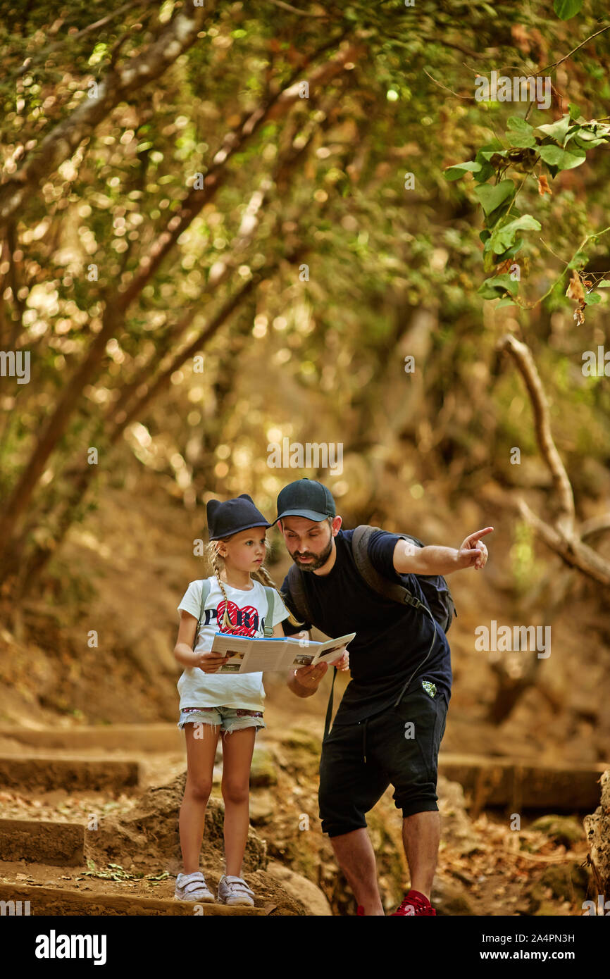 family dad and little cute daughter hiking in a forest Stock Photo