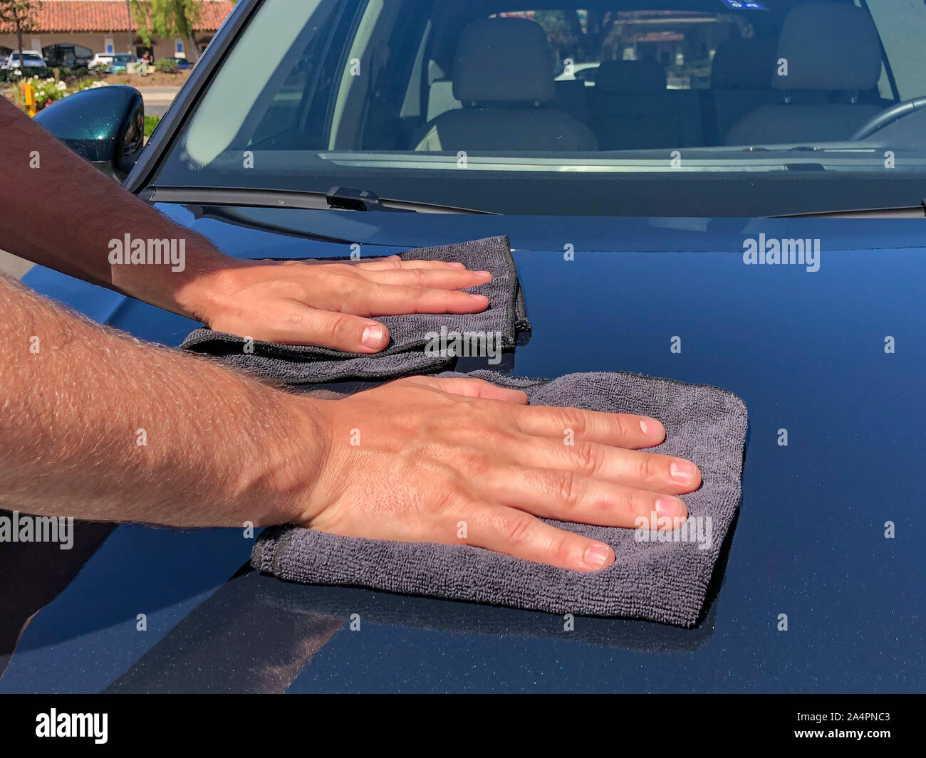 A man cleaning car with microfiber cloth, car detailing concept. Hand of employees worker use