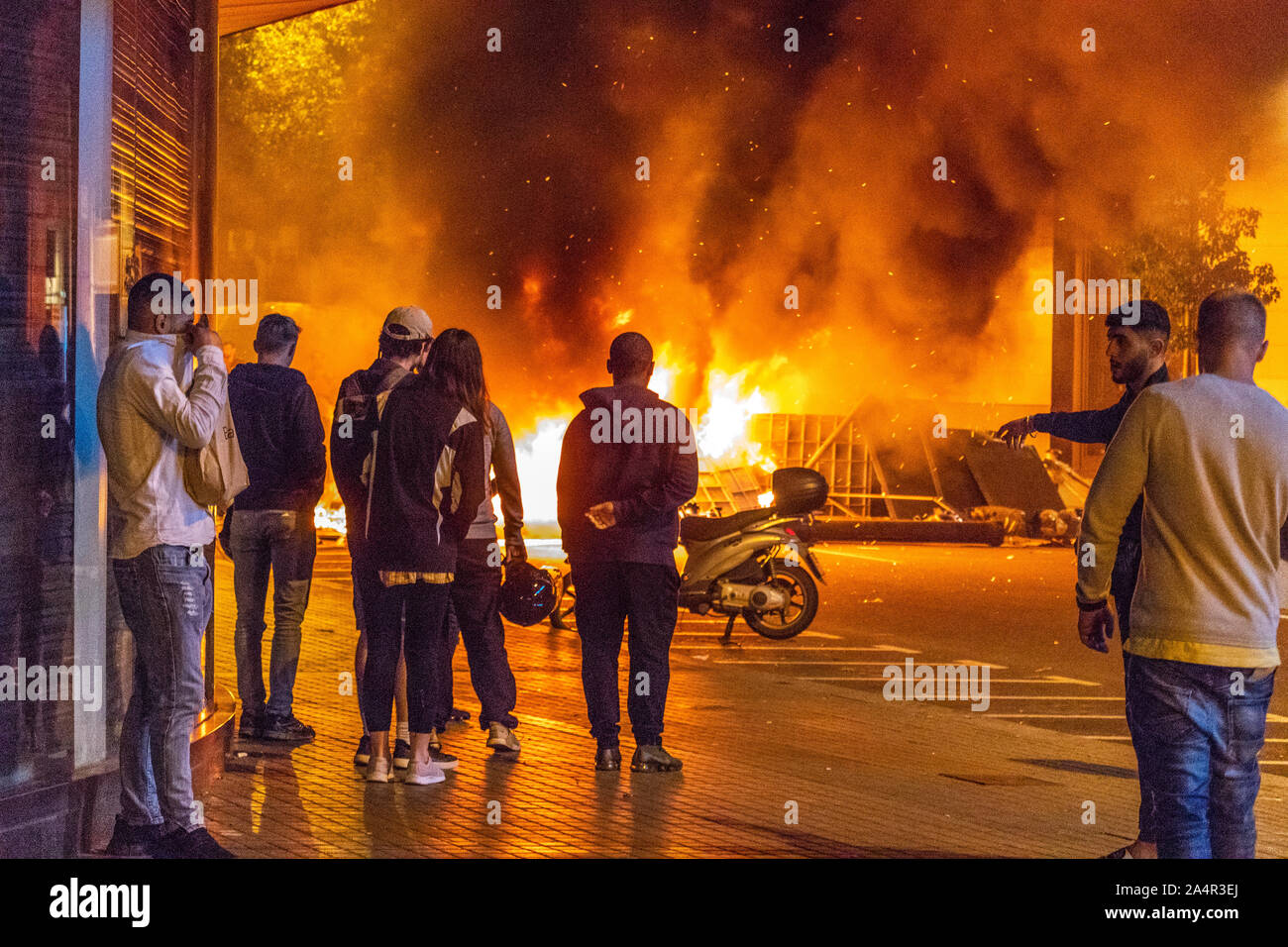 Barcelona, Spain - October 16, 2019: Tourists looking at the fire on the streets of Barcelona as part of the protests again the prison sentence to catalan leaders for organizing the independence referendum Credit: Dino Geromella/Alamy Live News Stock Photo