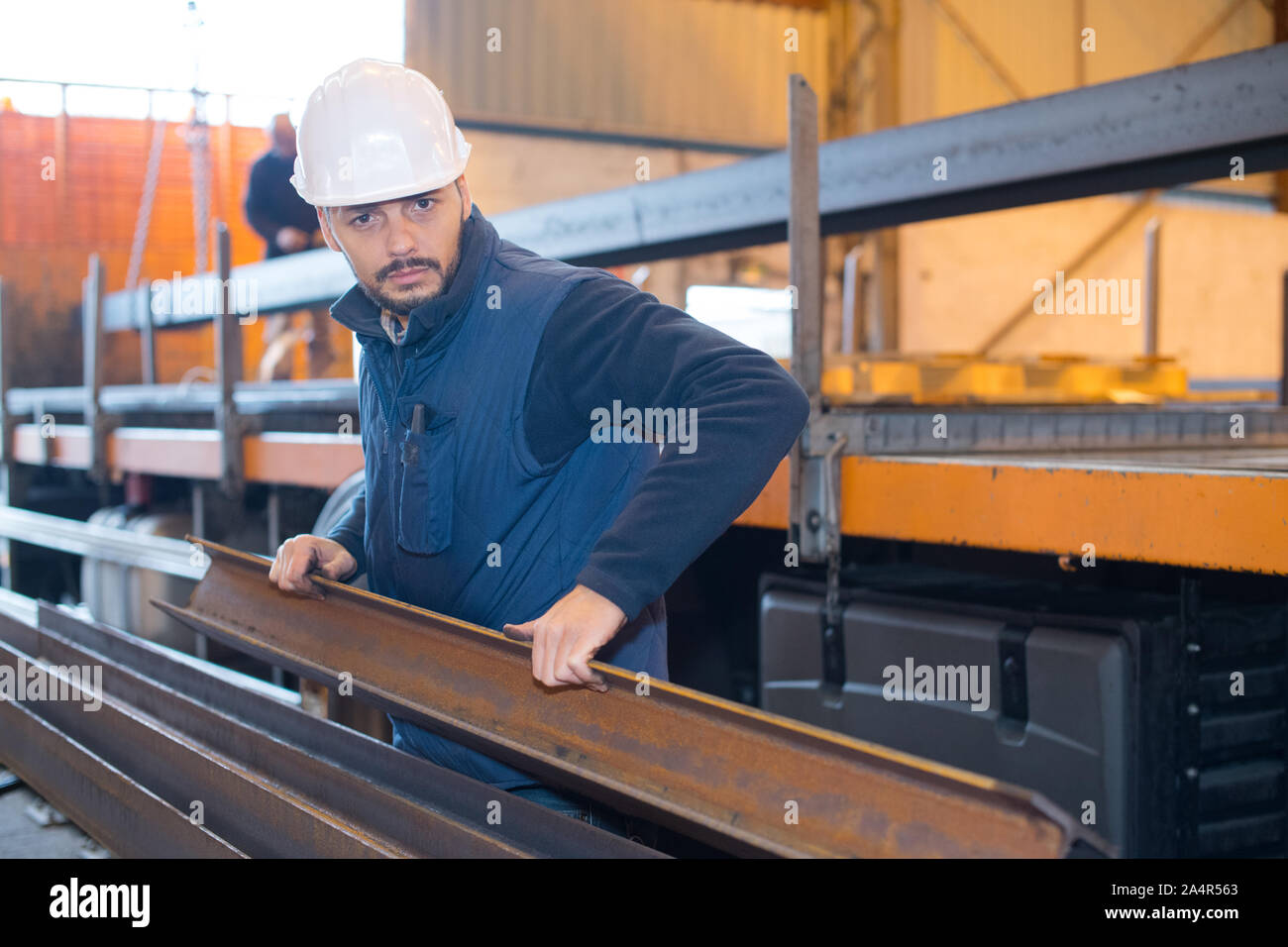man lifting rsj in factory Stock Photo Alamy