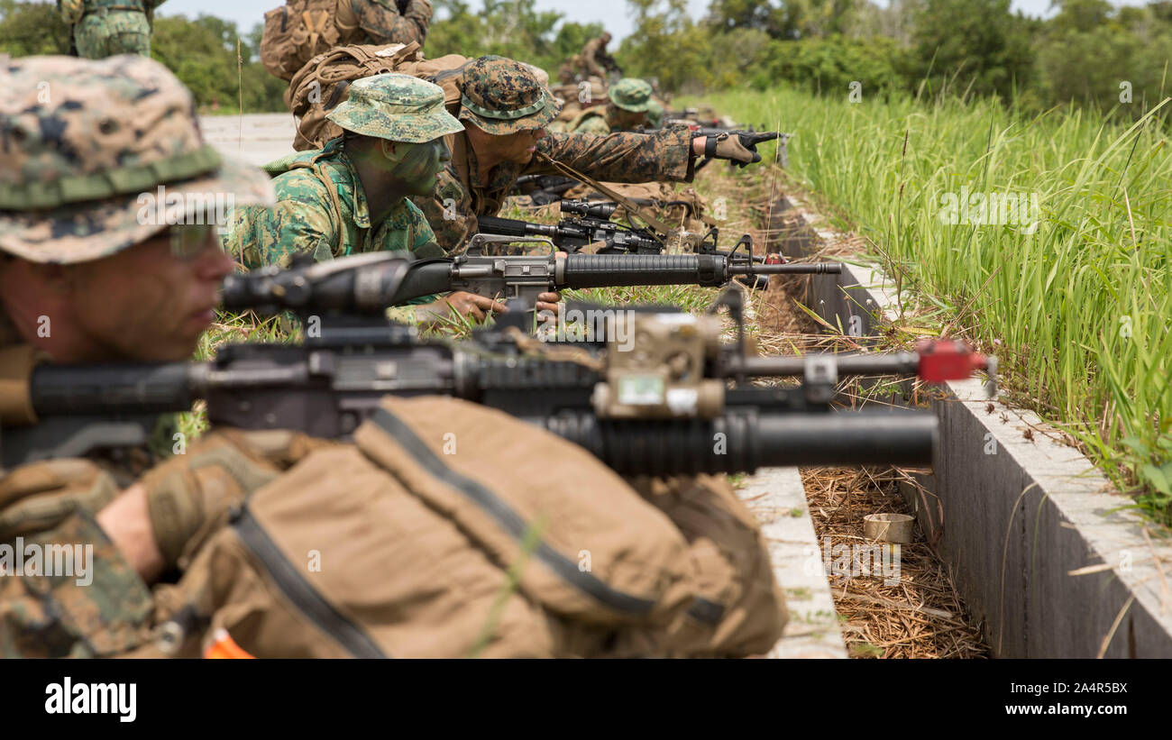 191007-M-QS181-1021 PENANJONG, BRUNEI (Oct. 7, 2019) U.S. Marines with India Company, Battalion Landing Team 3/5, 11th Marine Expeditionary Unit (MEU) and soldiers with the Royal Brunei Armed Forces set security after reaching an objective point. Elements of the 11th MEU are ashore in Brunei to perform day and night training in an urban environment and to enhance interoperability and partnership between the U.S. and Brunei during Combined Afloat Readiness and Training - Brunei 2019. (U.S. Marine Corps photo by Cpl. Jason Monty) Stock Photo