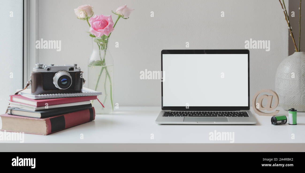 Open blank screen laptop computer with camera with roses vase and ...