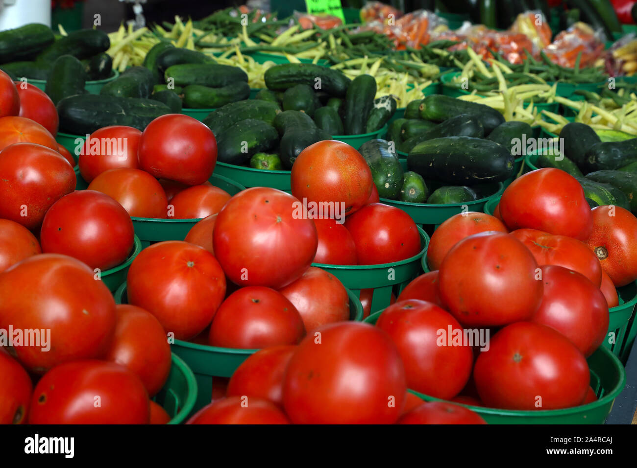 Biologic, natural cultivated tomatoes on a market counter. Vegetables from the farmers market. Ecologic products. Natural background. Stock Photo
