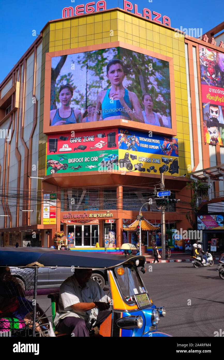 A tuktuk passes Mega Plaza, a shopping mall specializing in electronic