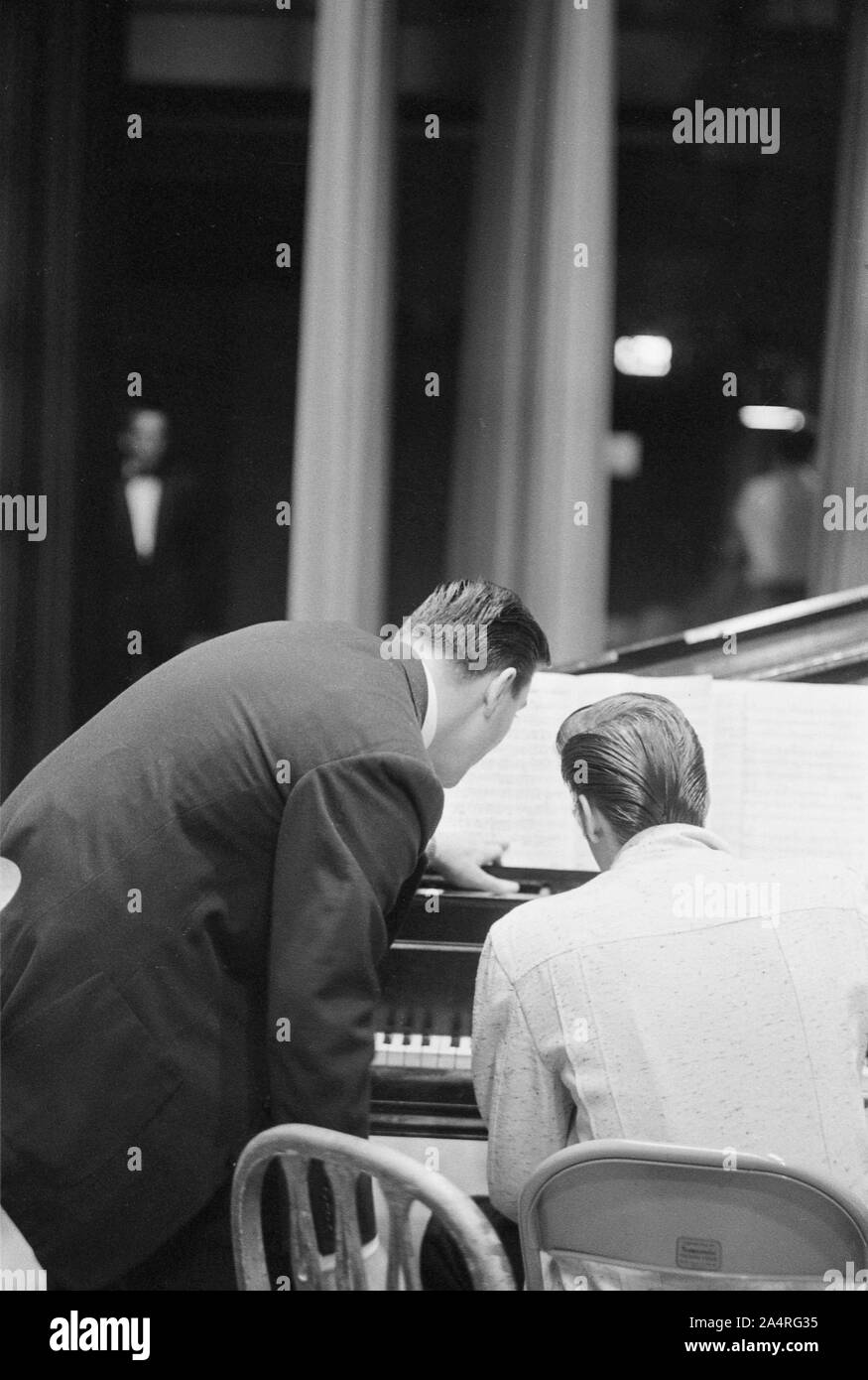 Elvis Presley waiting for a show to start, playing piano, at the