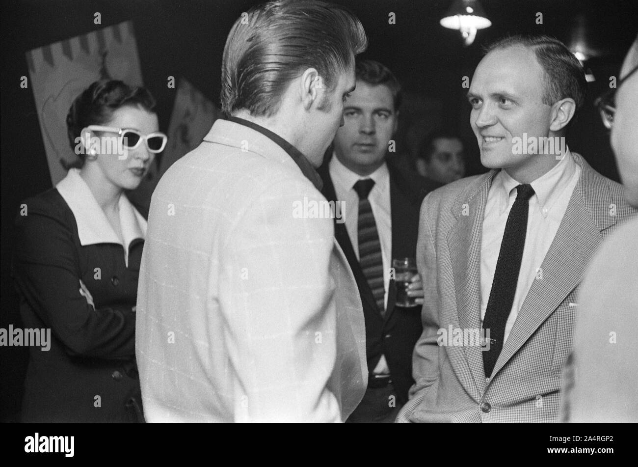 Elvis Presley speaking with fans at an adult party after his show at the Fox Theater, Detroit, Michigan, May 25, 1956. Stock Photo