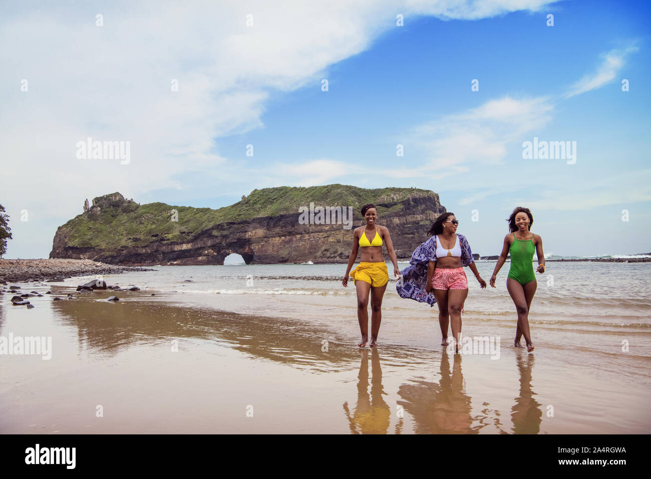 Three young women walking on the beach at Hole in the Wall, Coffee Bay Stock Photo