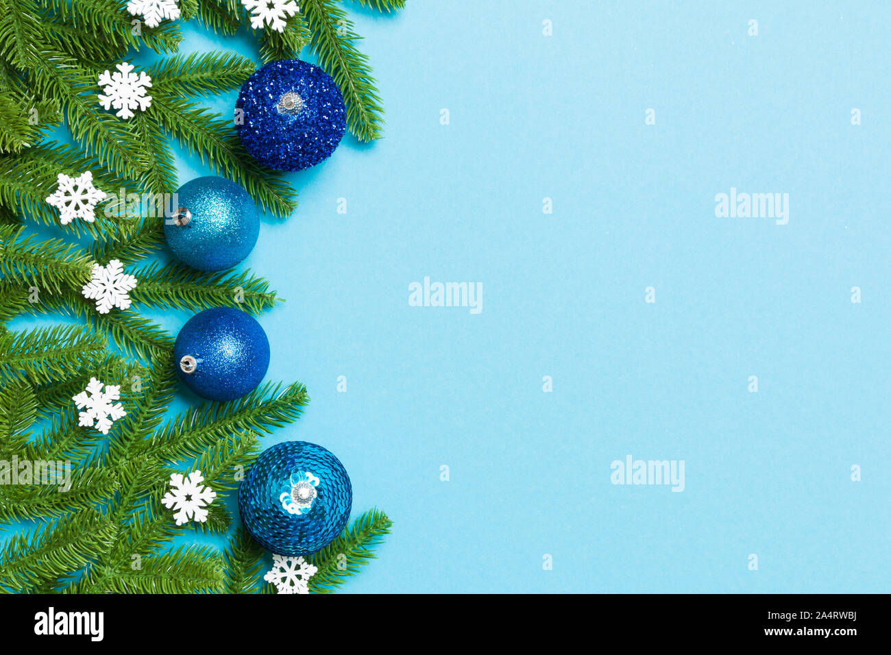 Christmas composition made of fir tree, balls and different decorations on colorful background. Top view of New Year Advent concept with empty space f Stock Photo