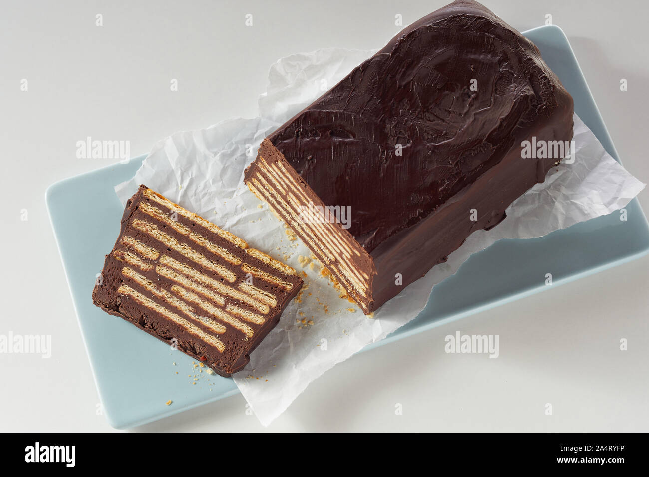 Top view of a Hedgehog slice or Kalter Hund biscuit chocolate cake, iced  with chocolate sitting on pale blue tray and crumpled white paper Stock  Photo - Alamy