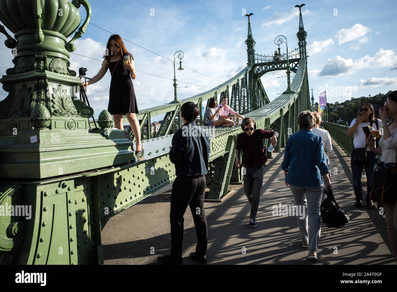 SZABADSAG HID BRIDGE BUDAPEST - 1894-1896 DESIGNED BY ARCHITECT JANOS FEKETEHAZY - TOURIST, LOVERS SEATING ON THE IRON BRIDGE STRUCTURE DURING A SUNNY DAY - BUDAPEST CITY - BUDAPEST BRIDGE - BUDAPEST STREET PHOTOGRAPHY - HUNGARY © Frédéric BEAUMONT Stock Photo