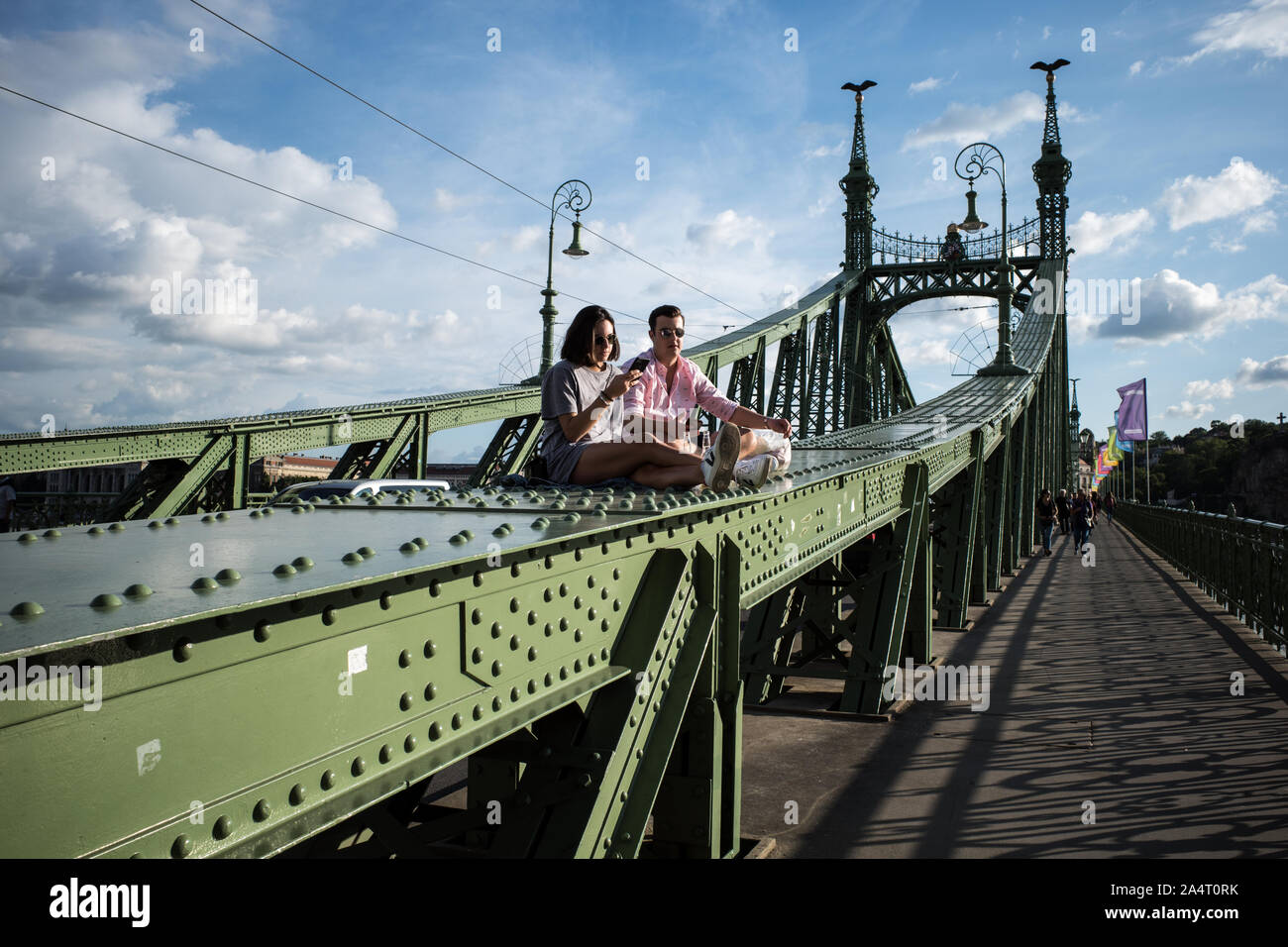 SZABADSAG HID BRIDGE BUDAPEST - 1894-1896 DESIGNED BY ARCHITECT JANOS FEKETEHAZY -  LOVERS SEATING ON THE IRON BRIDGE STRUCTURE DURING A SUNNY DAY - BUDAPEST CITY - BUDAPEST BRIDGE - BUDAPEST STREET PHOTOGRAPHY - HUNGARY © Frédéric BEAUMONT Stock Photo