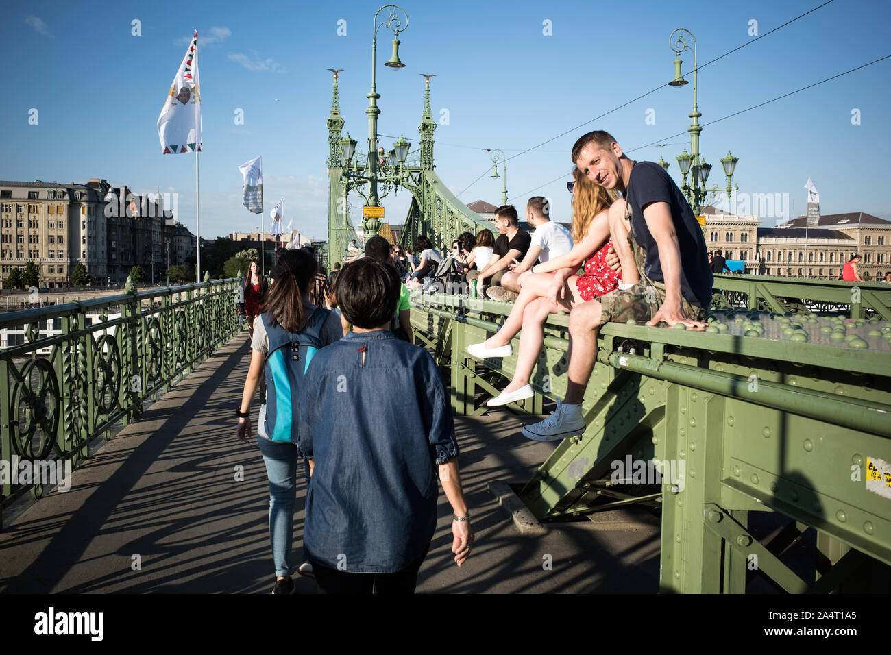 SZABADSAG HID BRIDGE BUDAPEST - 1894-1896 DESIGNED BY ARCHITECT JANOS FEKETEHAZY - LOVERS SEATING ON THE IRON BRIDGE STRUCTURE DURING A SUNNY DAY - BUDAPEST CITY - BUDAPEST BRIDGE - BUDAPEST STREET PHOTOGRAPHY - HUNGARY © Frédéric BEAUMONT Stock Photo