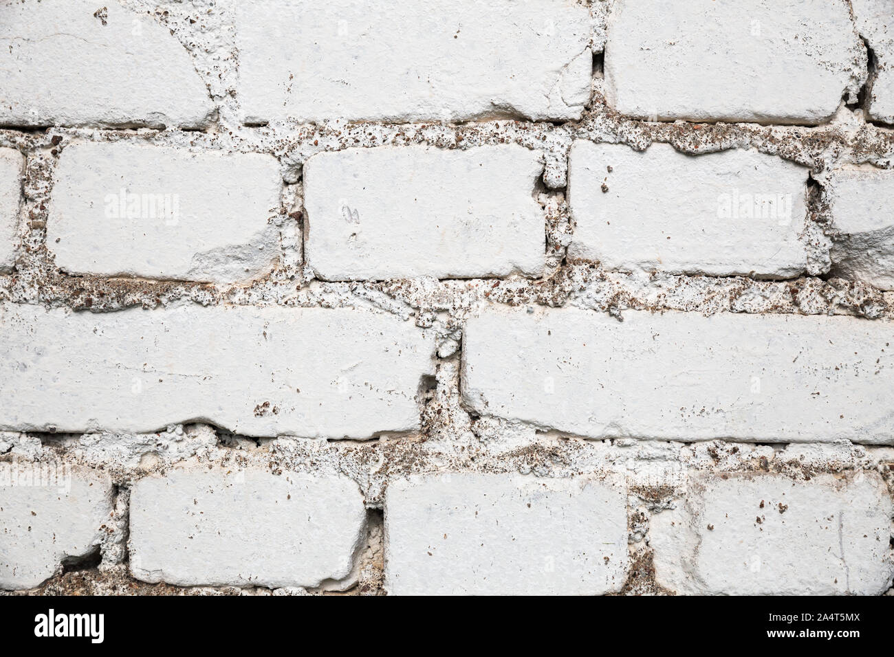 Abstract background, texture of an old white brick wall, with ugly sloppy seams Stock Photo