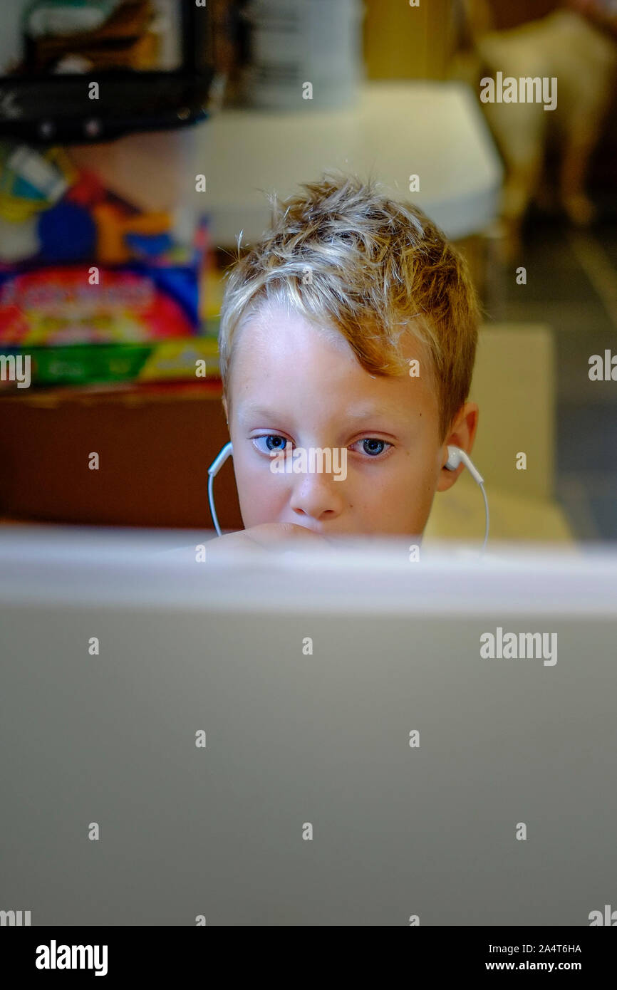 A young boy engrossed in playing a computer video game. Stock Photo