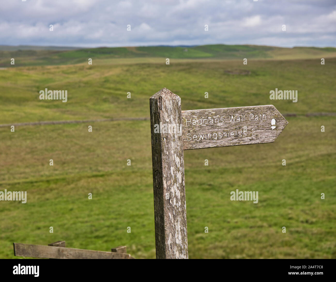 Wooden sign pointing to Hadrian's Wall path at Housesteads Roman Fort, Hadrian's Wall, Northumberland, England Stock Photo